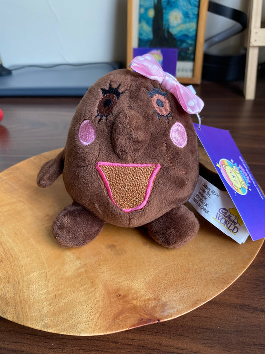 Chucklebean Girl plush from Cadabra ride—brown bean-shaped toy with embroidered cheeks and pink ribbon