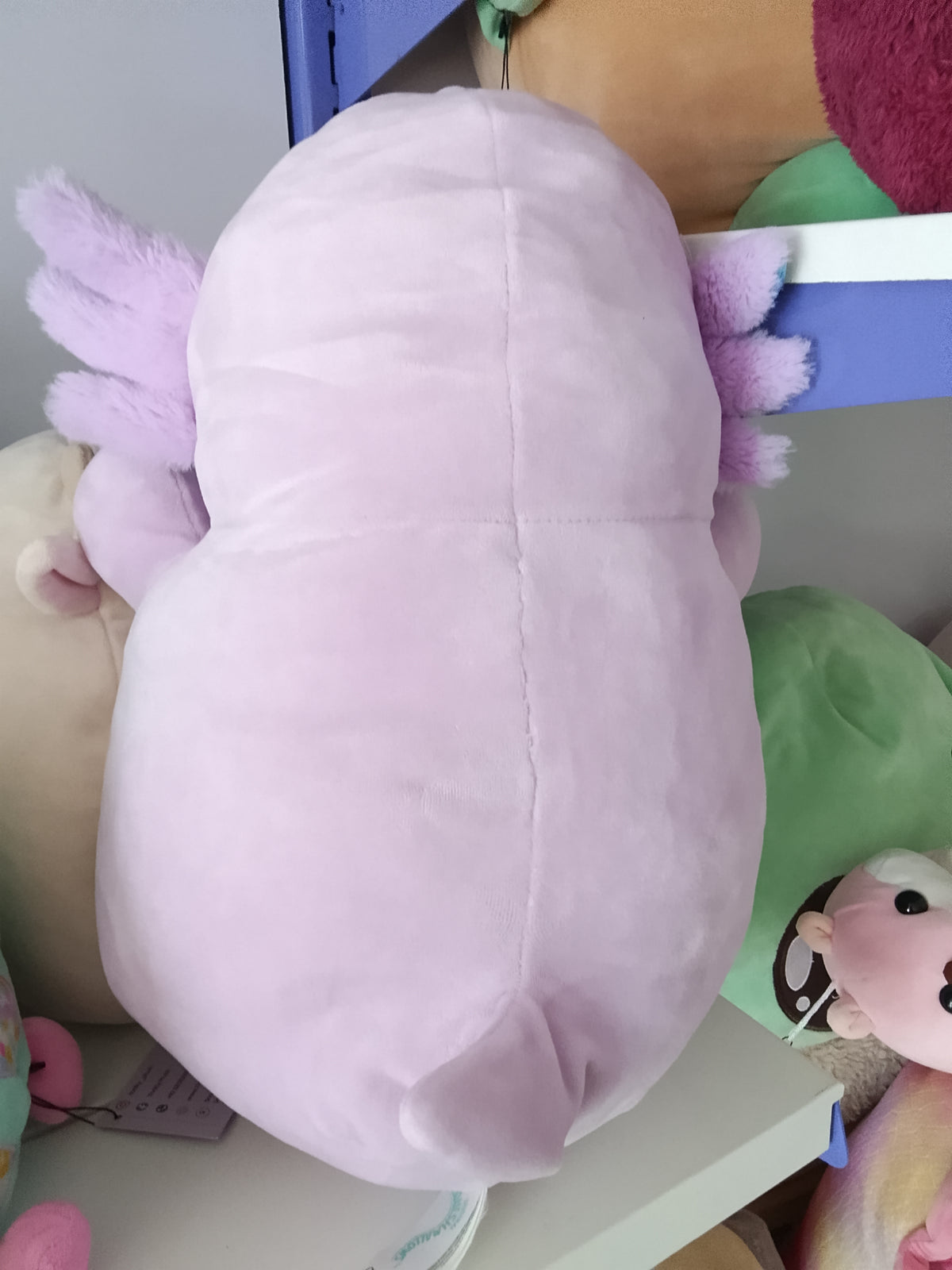 Monica the Axolotl, a light purple character from the Squishmallows Hug Mees line by Kellytoy.