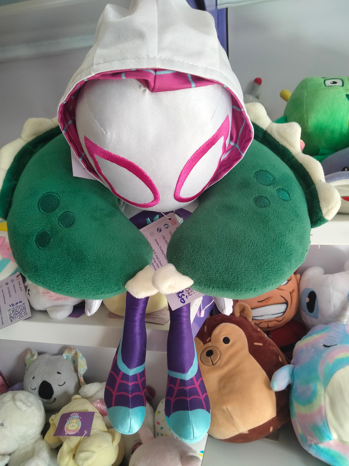 This is a green dinosaur-themed travel neck pillow from Thrifty Plush.