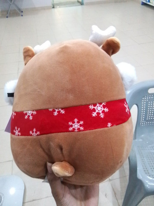 Squishmallows plush toy Darla the Fawn, complete with holiday earmuffs and a red scarf.