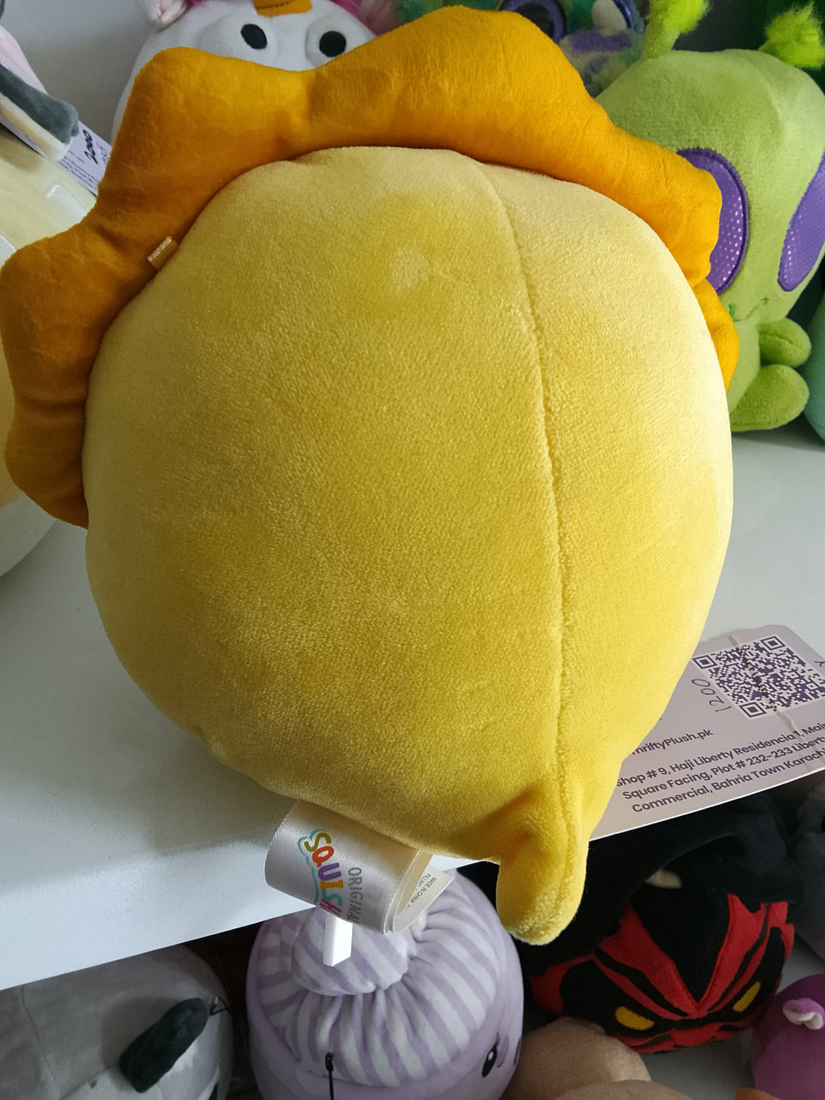 Squishmallows Lancaster the Triceratops, yellow color, soft texture, and dinosaur design plush toy.