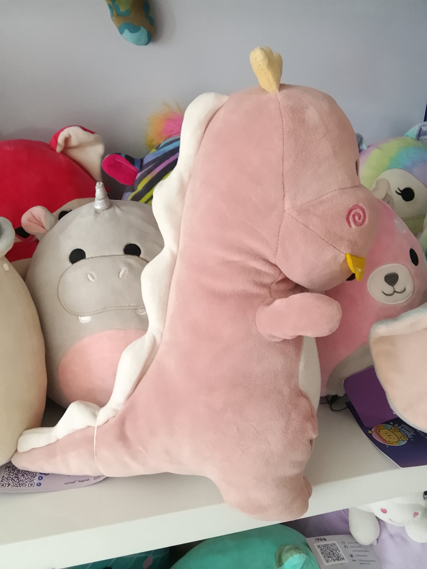 Pink dinosaur plush toy designed for children.