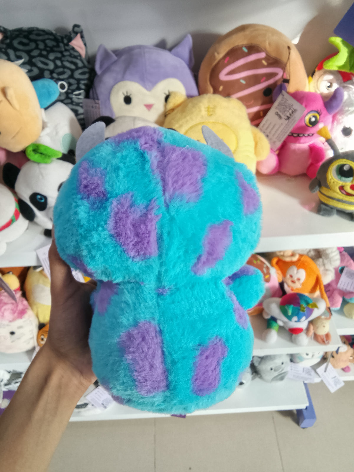 Monsters, Inc. Sulley plush doll by Disney Store or similar brands like Miniso.