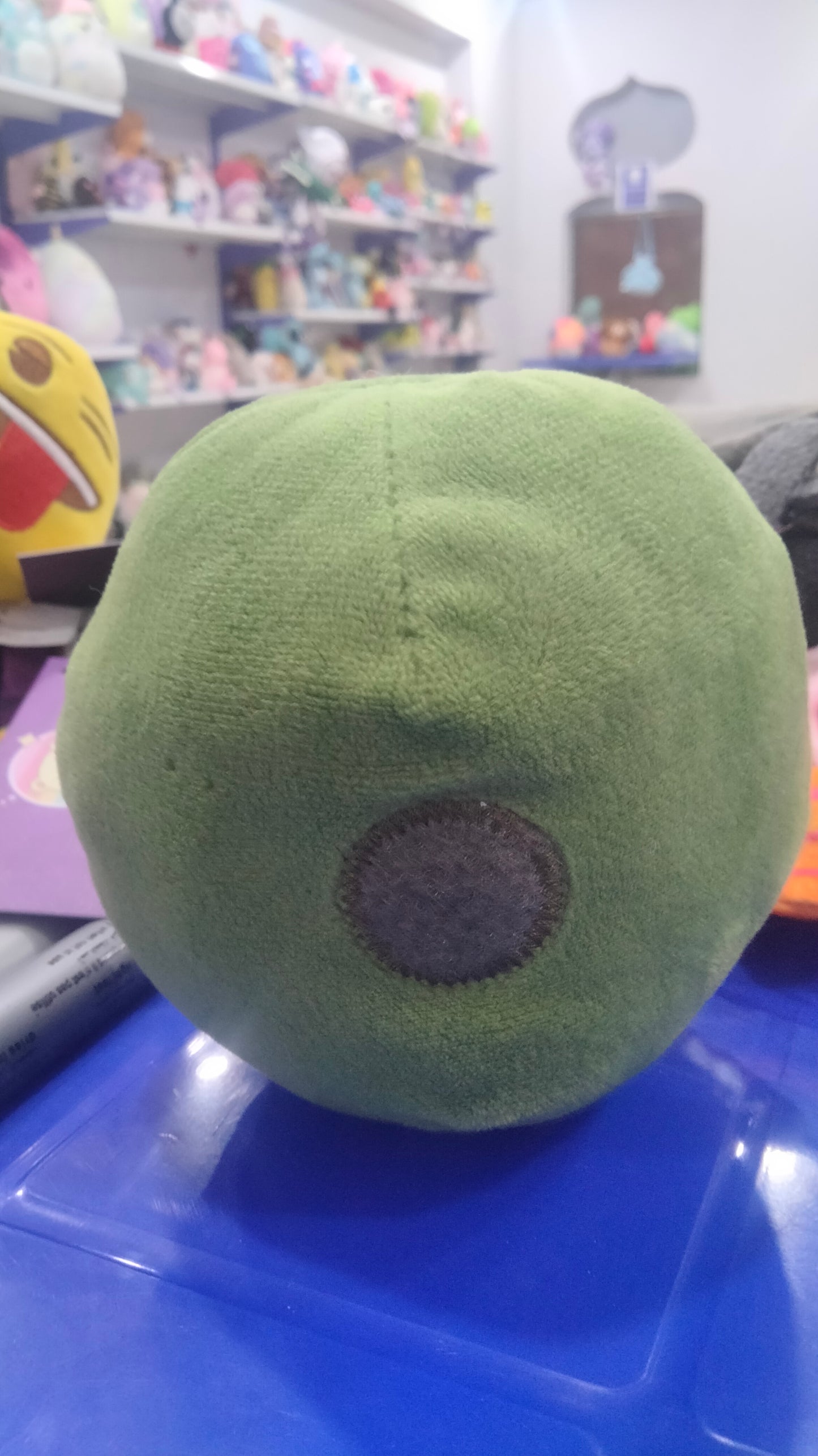 green plush toy that resembles a Brussels sprout or a slime character.