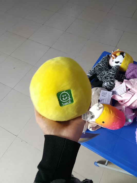 yellow emoji plush toy with sunglasses and a smiling expression.