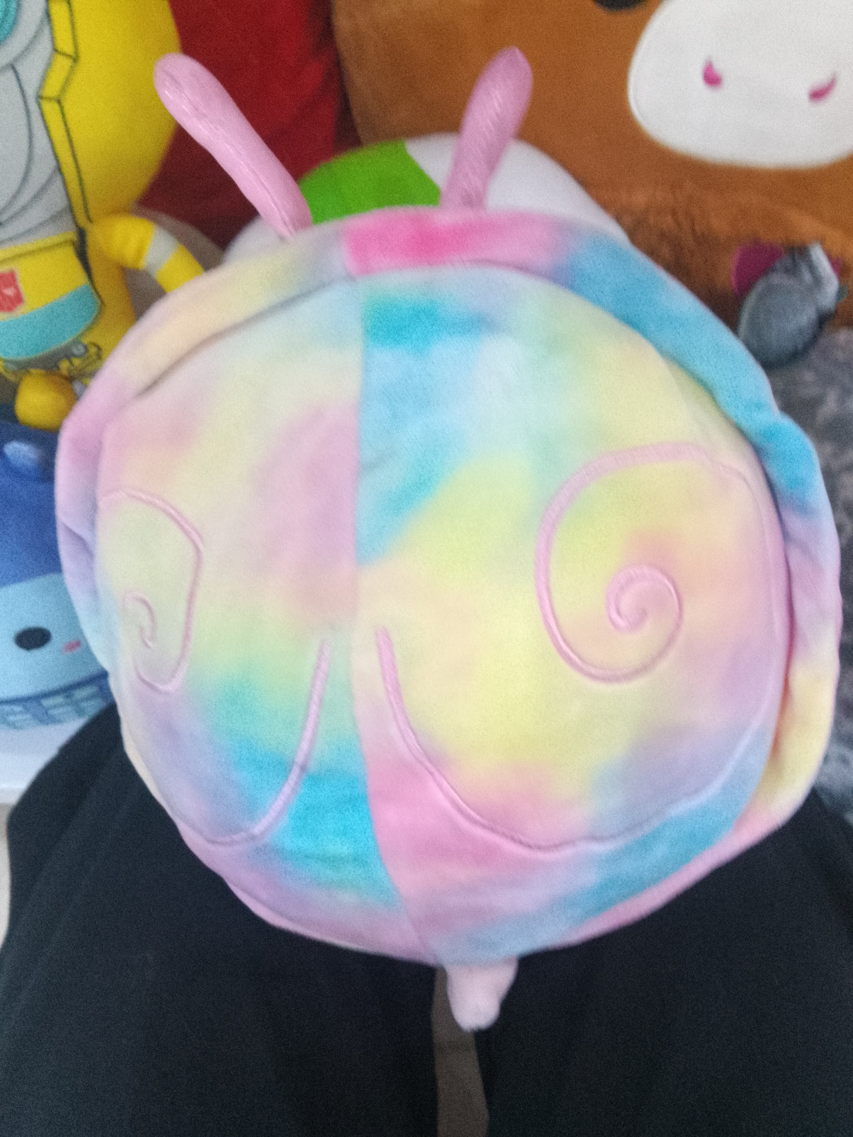 Squishmallow plush toy named Silvina the Snail, glittery antennae and a pastel tie-dye shell.