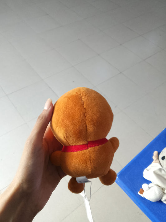 plush gingerbread man toy featuring a red scarf and green buttons.