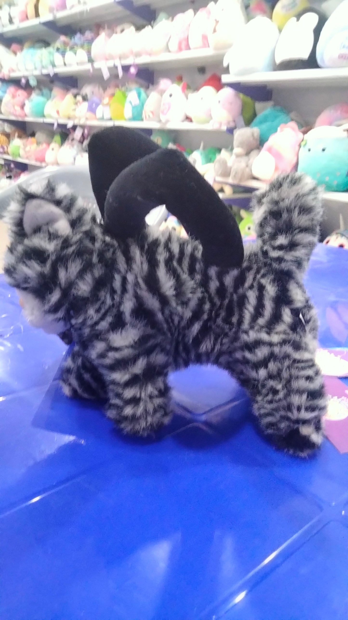 This is a grey and black striped plush cat toy
