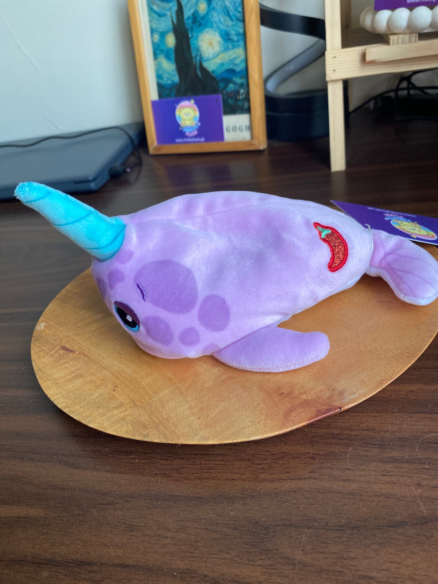 Unwrapped Cutetitos Series 2 Narwhalito plush: a light purple narwhal with a teal horn and embroidered eyes, shown revealed from its burrito-style blanket.