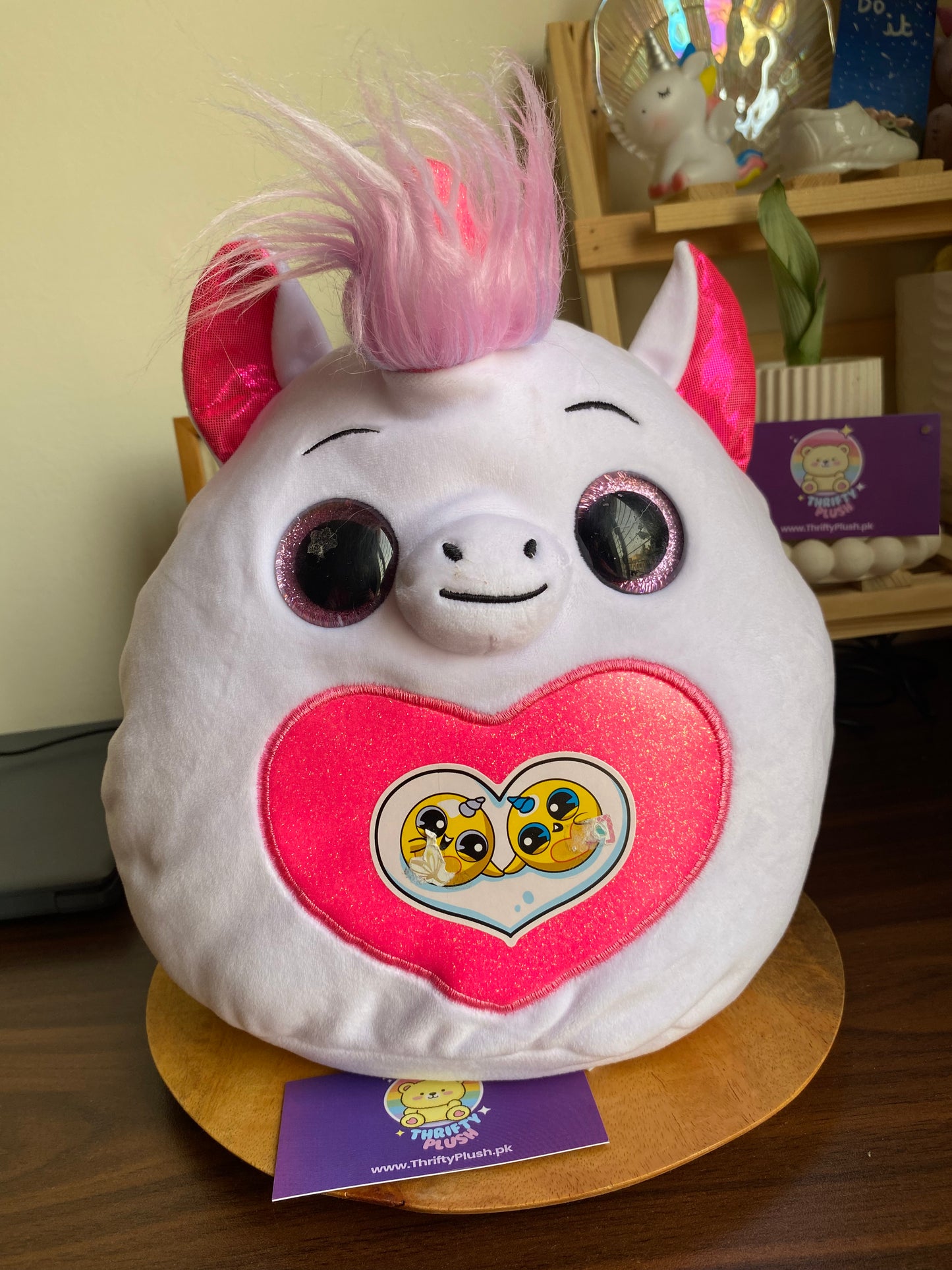 Photo of a Rainbocorns Fairycorn Surprise collectible plush unicorn emerging from a colorful surprise egg, accompanied by a pair of sparkly fairy wings, a tiara, and a magic wand.