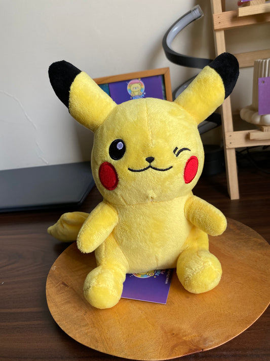 Front view of Pikachu plush, yellow with black-tipped ears and red cheeks