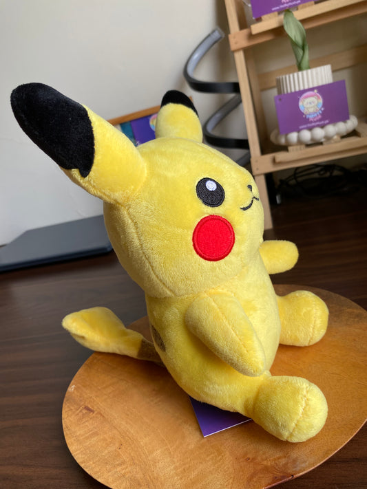 Front view of Pikachu plush, yellow with black-tipped ears and red cheeks