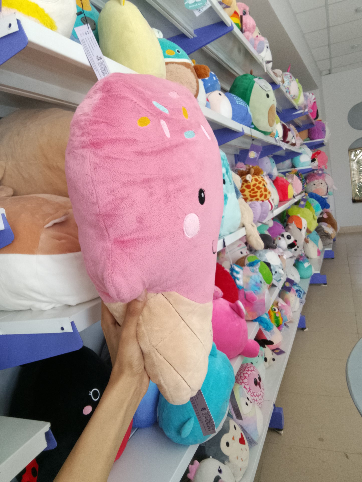 Squishmallows pink ice cream cone plush toy.