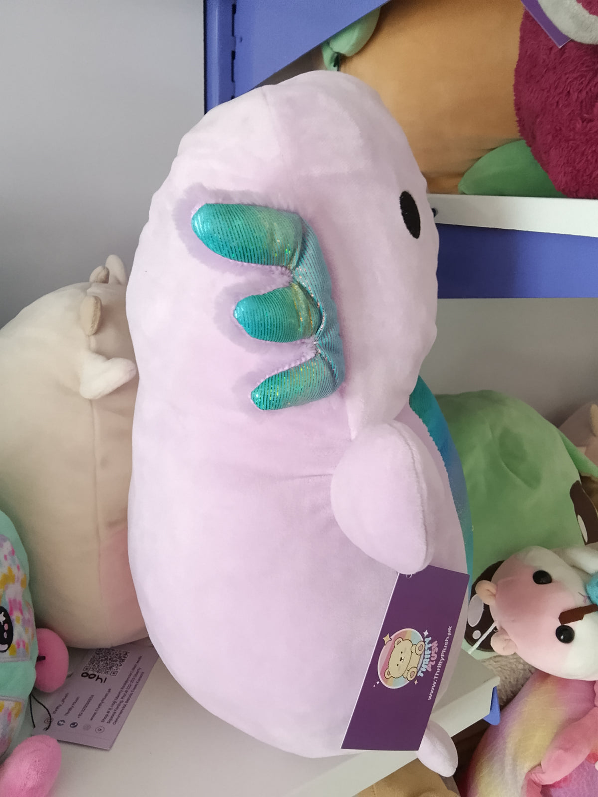 Monica the Axolotl, a light purple character from the Squishmallows Hug Mees line by Kellytoy.