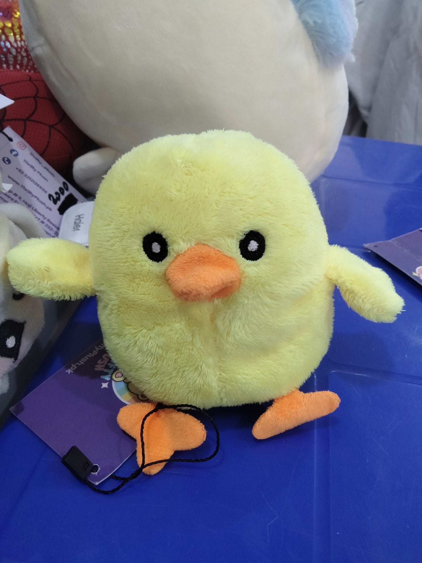 yellow plush chick toy with orange feet and beak.