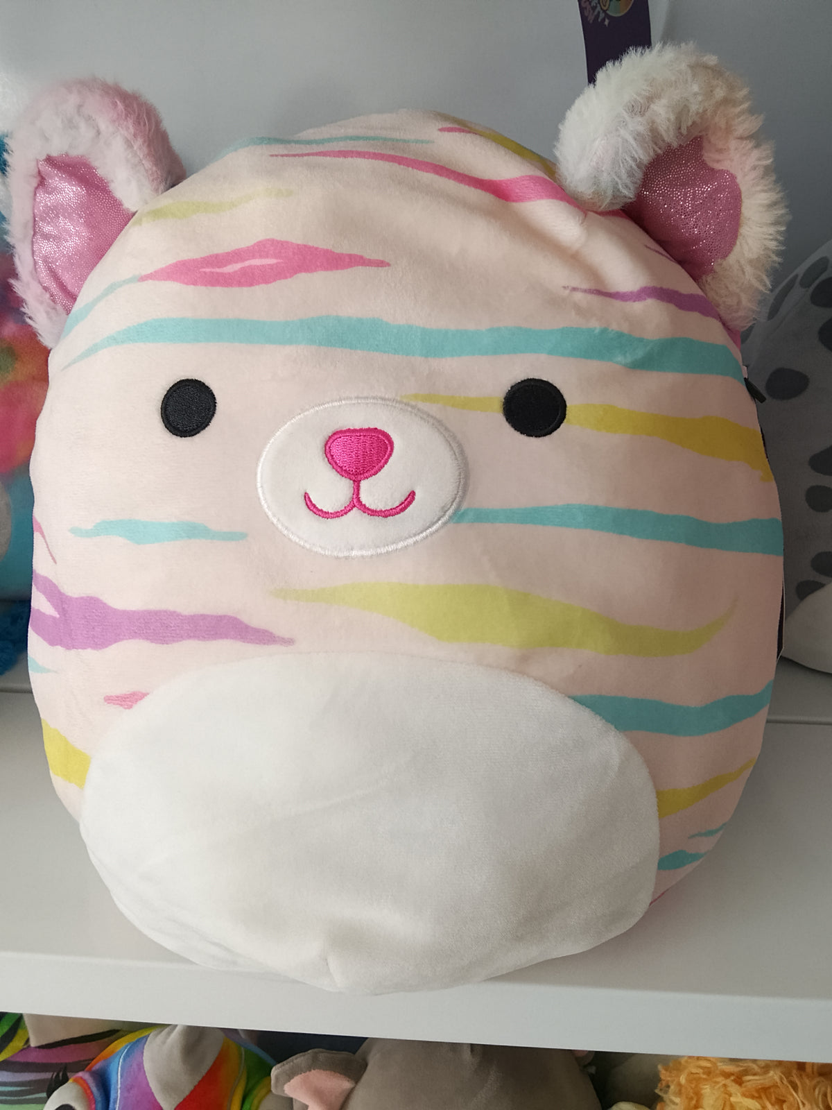 Squishmallows Atoosa the Cat, pastel rainbow stripes and shimmering pink ears plush toy.
