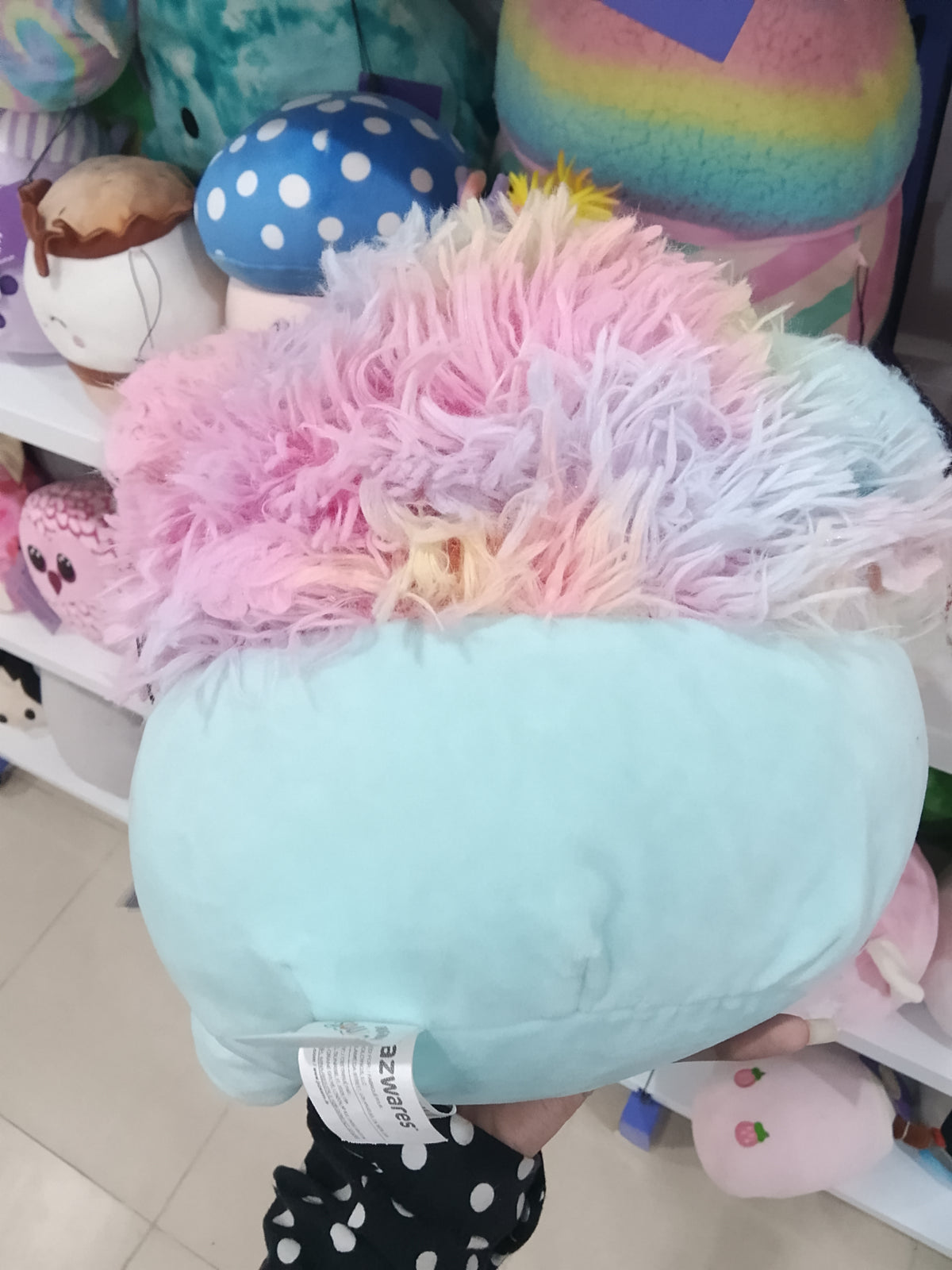 Squishmallows Zozo the Bigfoot plush toy in blue with rainbow hair.