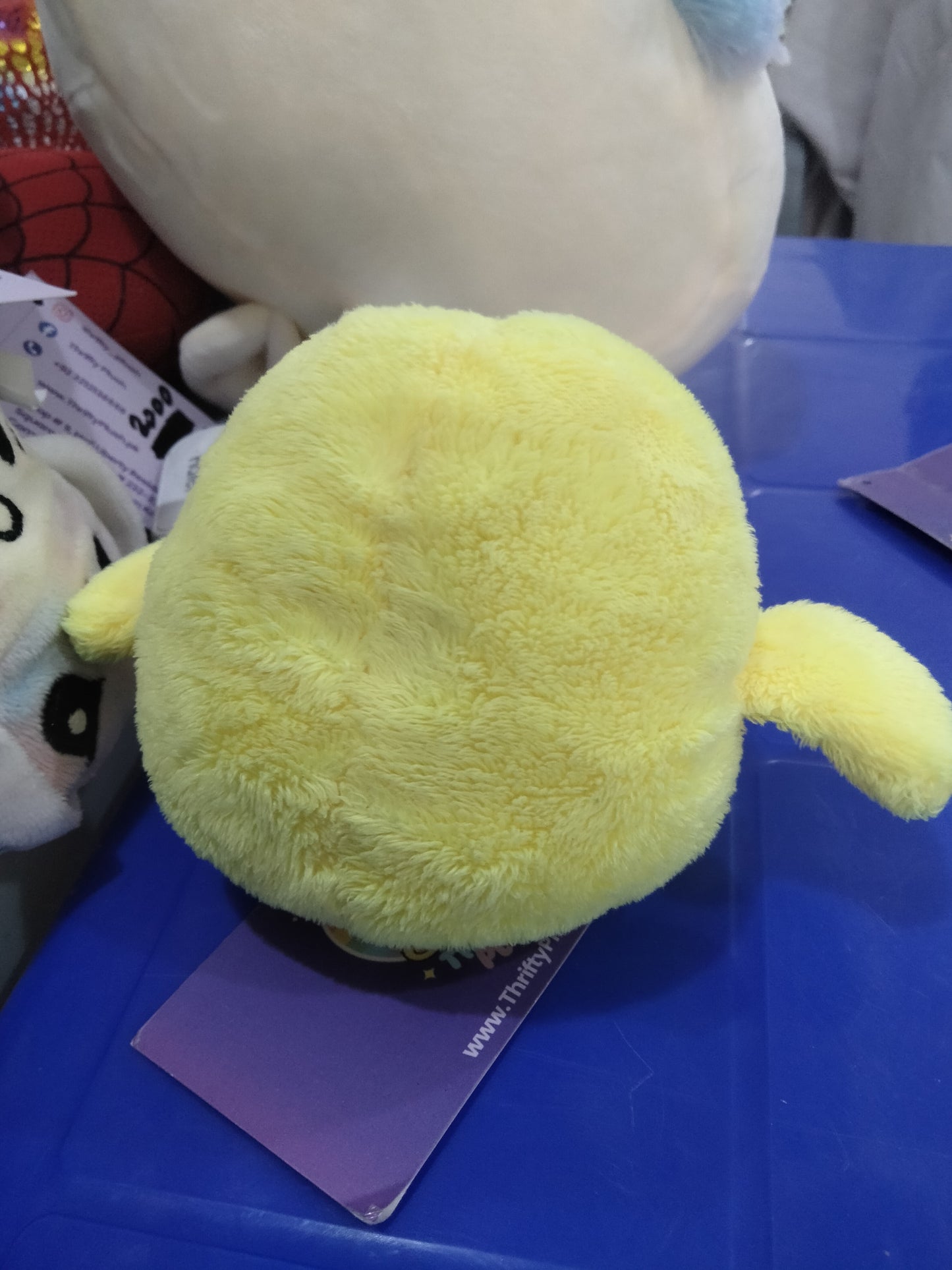 yellow plush chick toy with orange feet and beak.