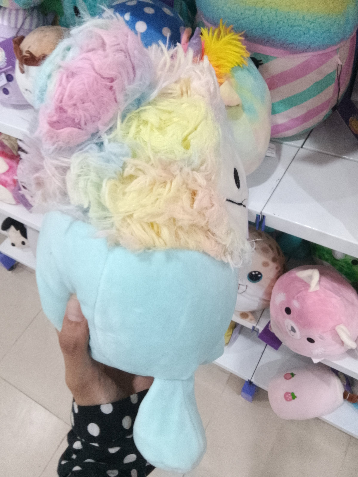 Squishmallows Zozo the Bigfoot plush toy in blue with rainbow hair.