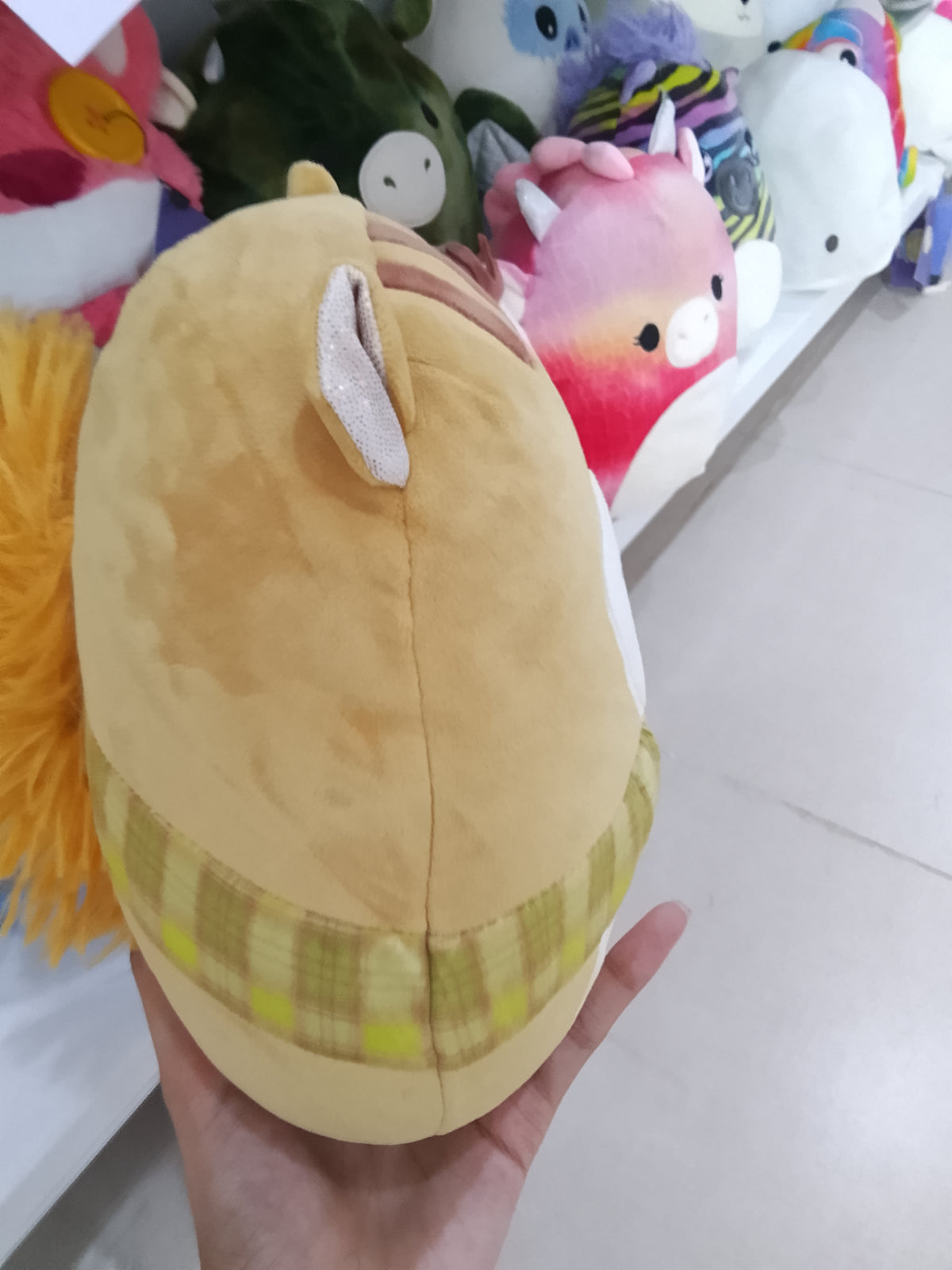 Squishmallows plush toy of Erin the Squirrel wearing a plaid scarf.