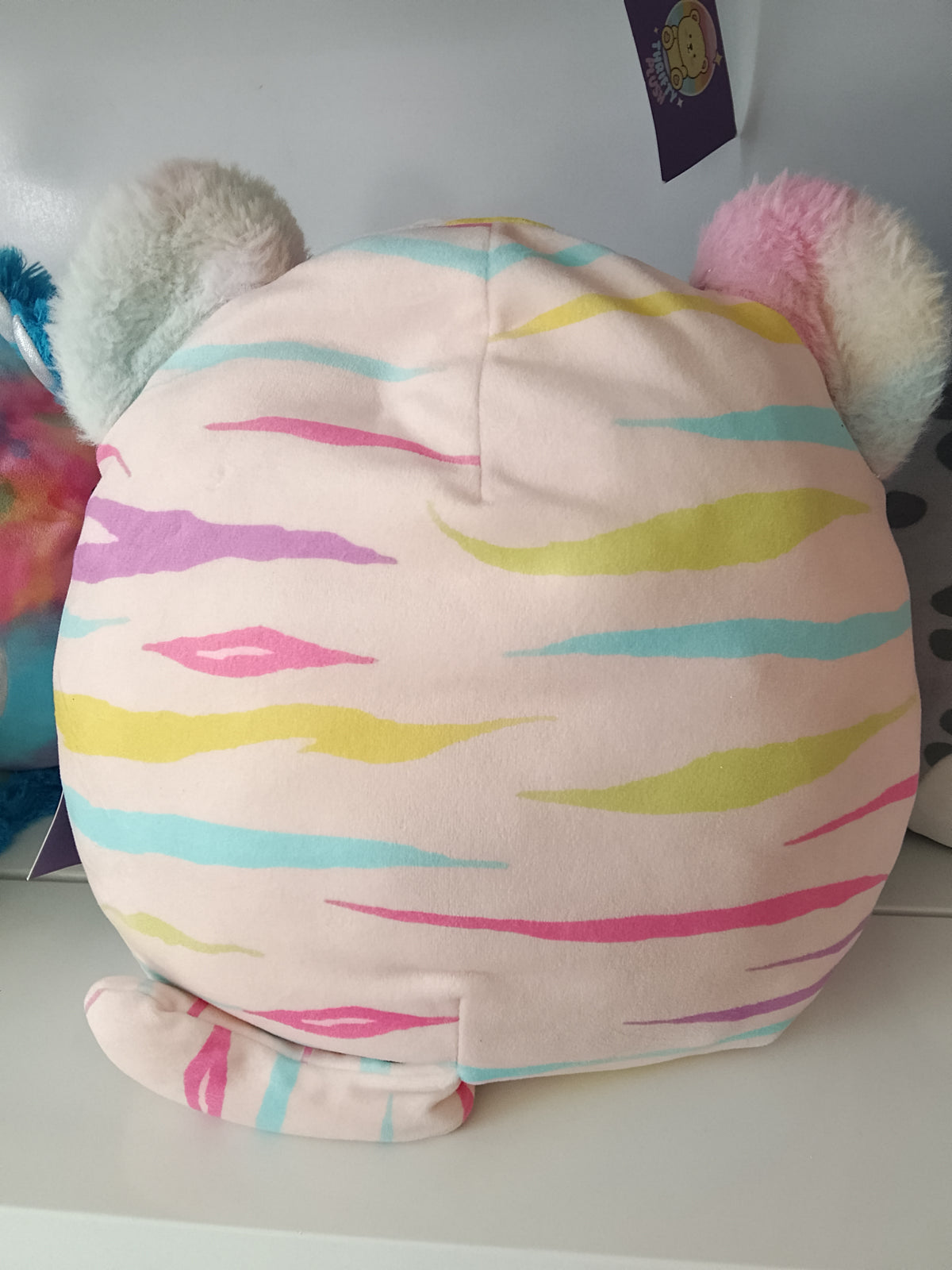 Squishmallows Atoosa the Cat, pastel rainbow stripes and shimmering pink ears plush toy.