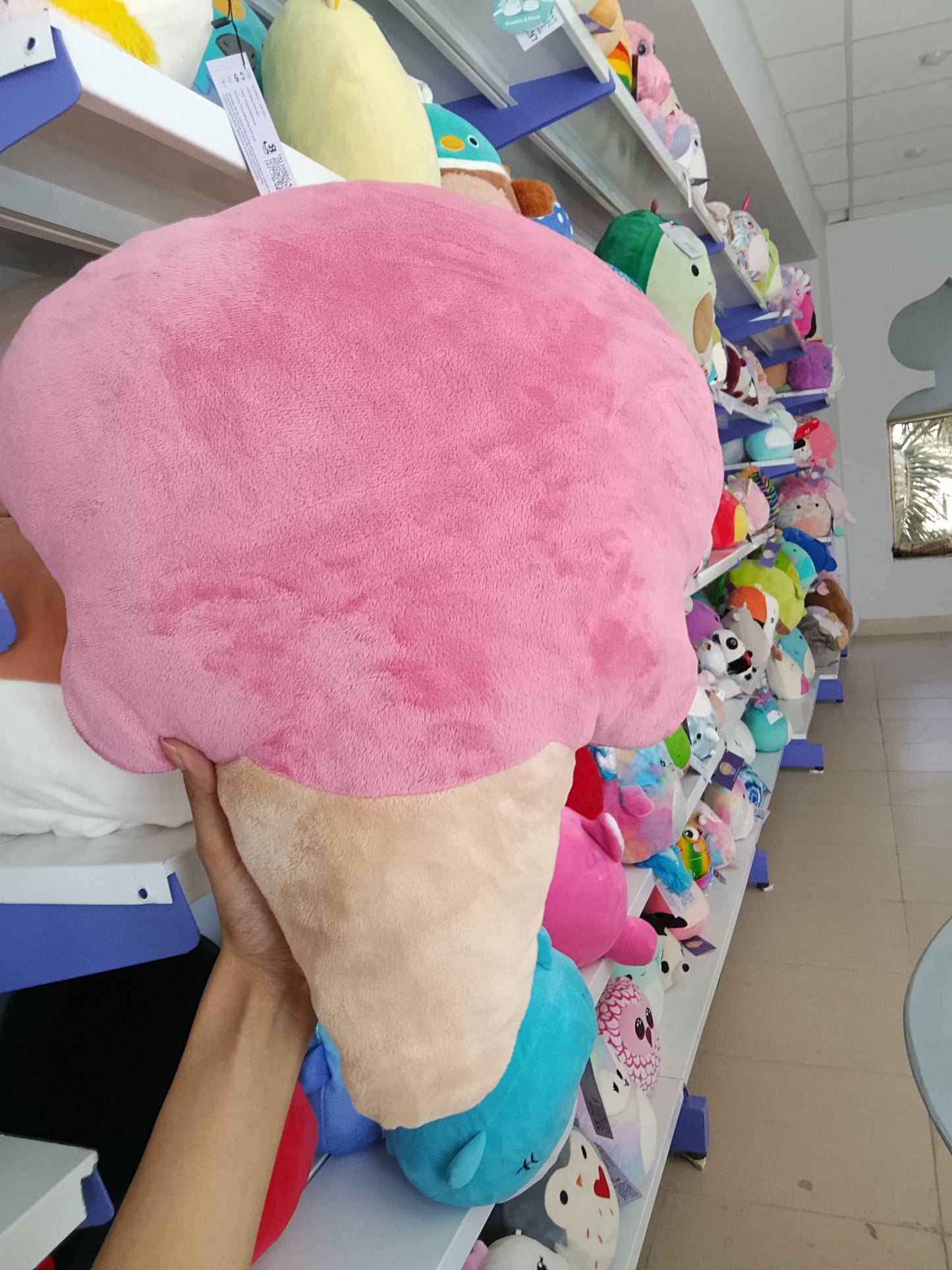 Squishmallows pink ice cream cone plush toy.