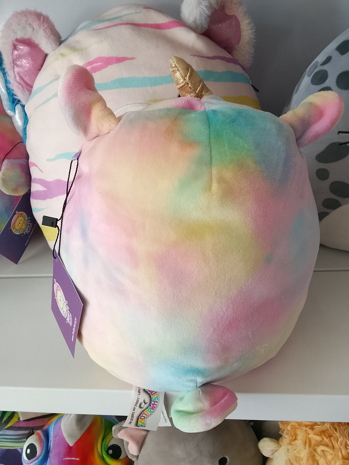 Squishmallows Lucinda the Llamacorn plush toy, featuring a rainbow tie-dye design.