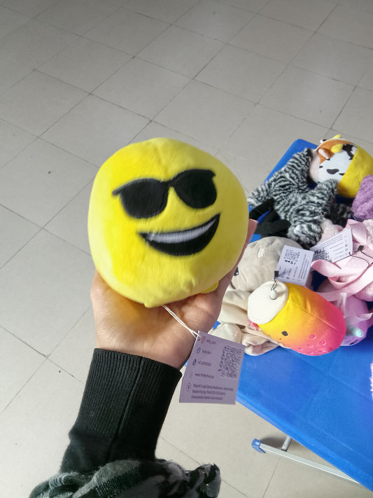 yellow emoji plush toy with sunglasses and a smiling expression.