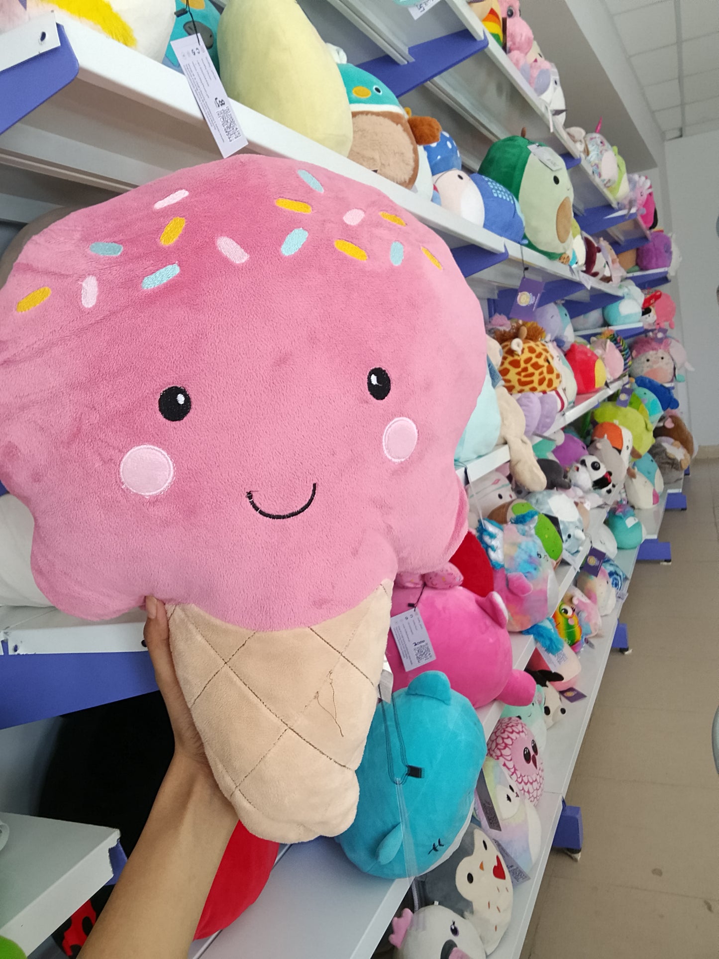 Squishmallows pink ice cream cone plush toy.