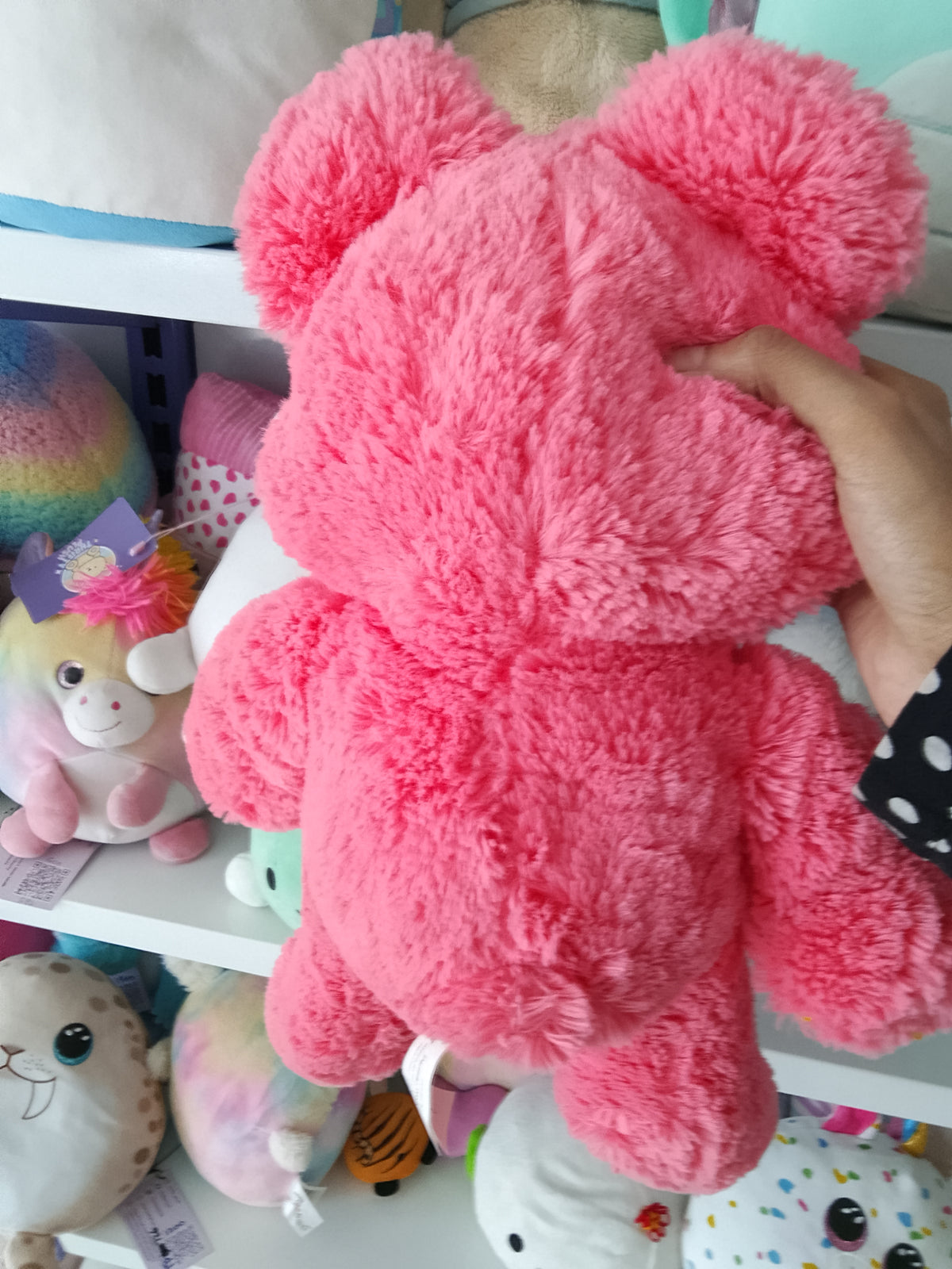 Fairgame brand pink teddy bear plush toy with a yellow button eye and a stitched "X" eye.
