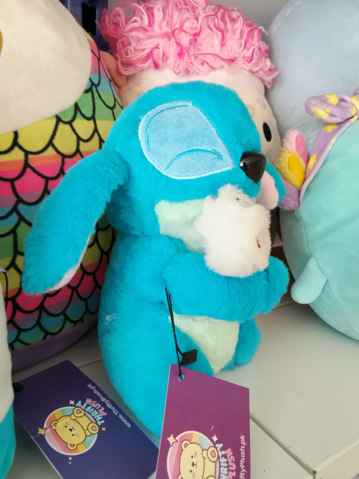 Stitch holding a smaller white duck Plush toy.