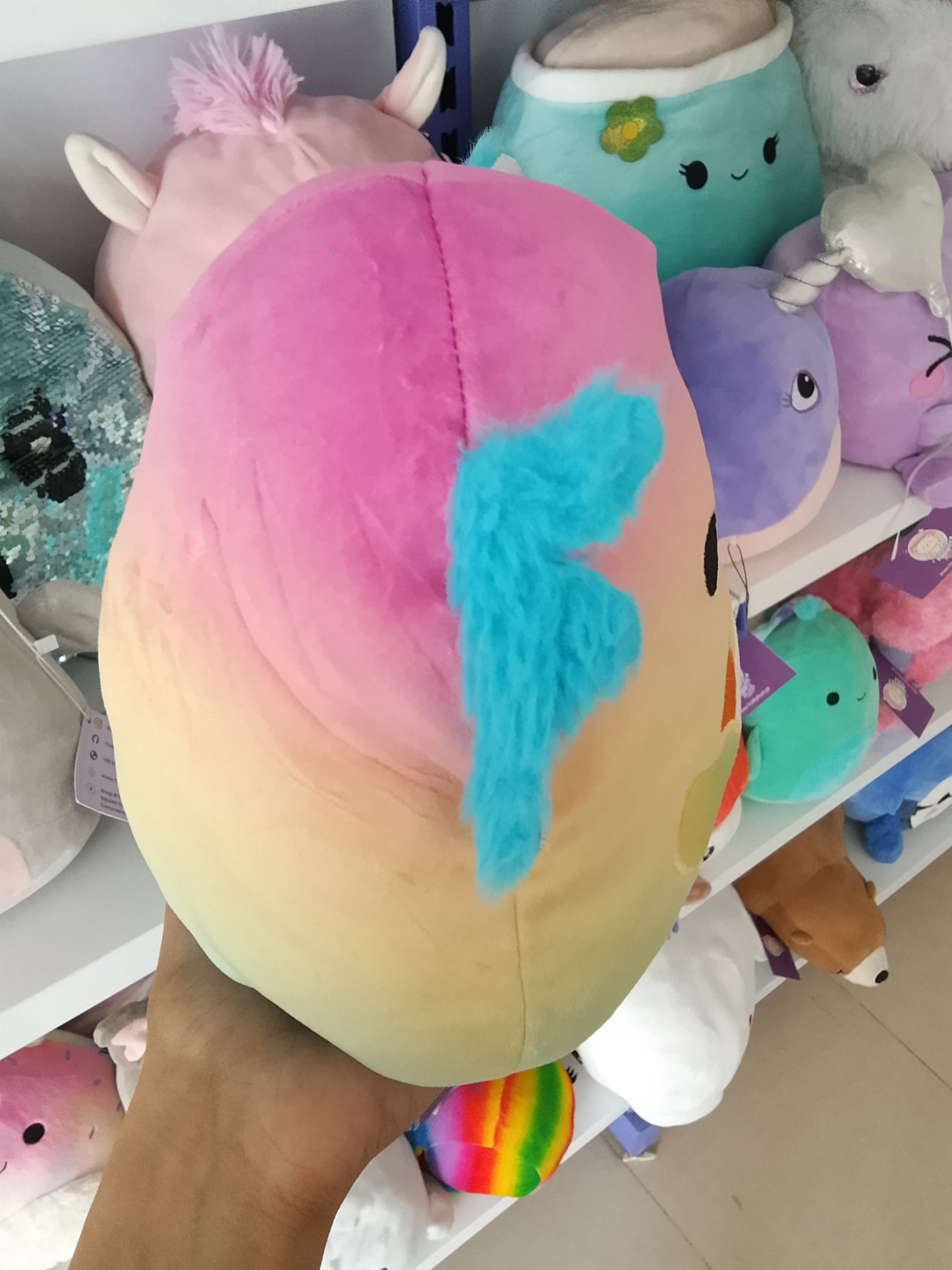 Squishmallows Flip-A-Mallows Aika the Axolotl plush rainbow design and holding a French fry carton.