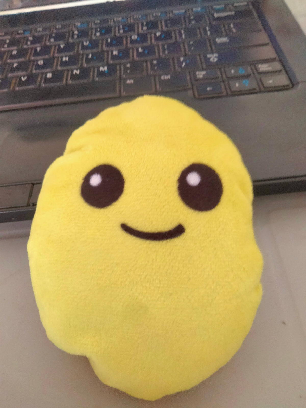 smiley emoji pillow with plush yellow fabric.