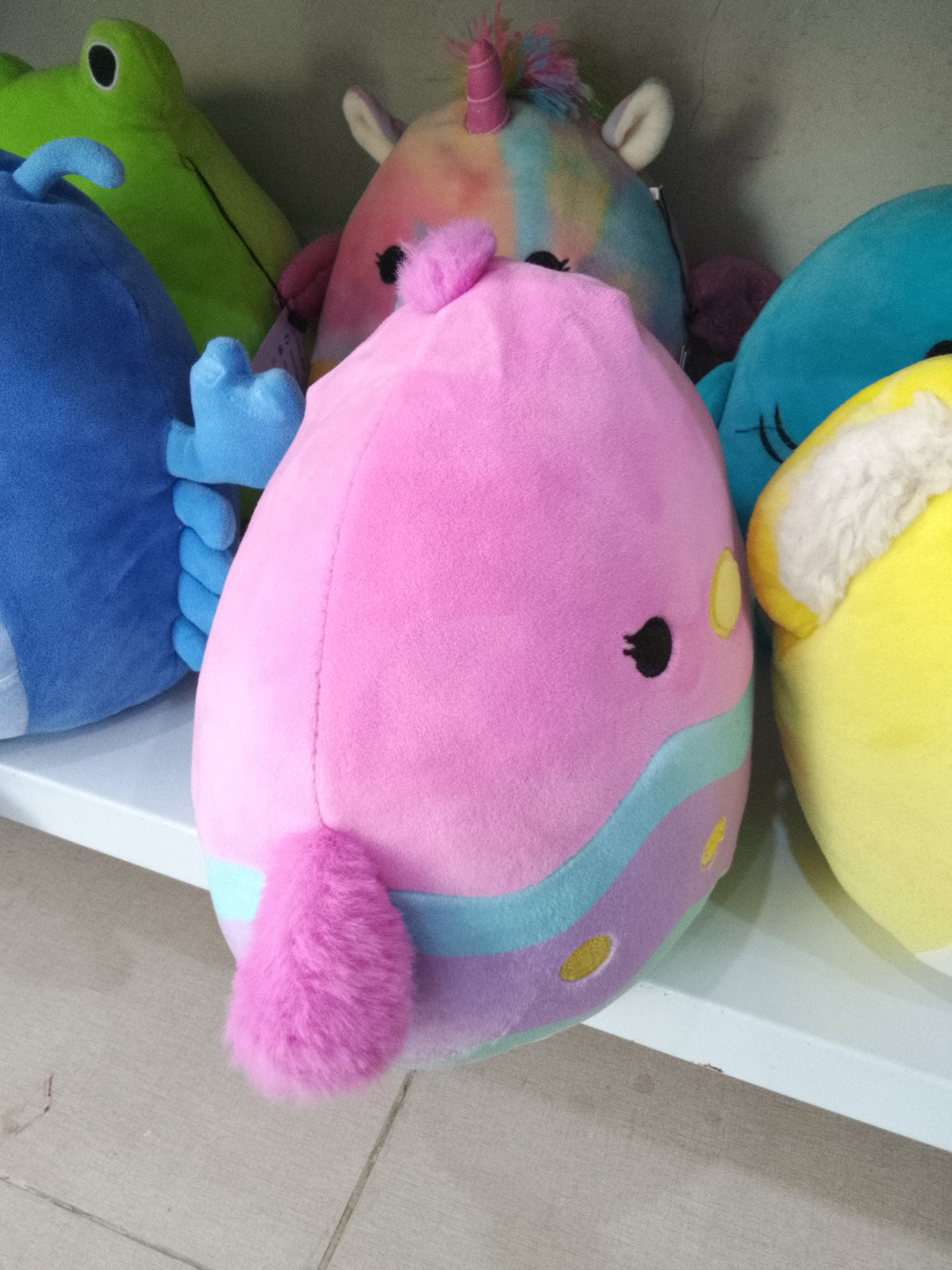Squishmallows Empressa the Chick plush toy with a pink, blue, and yellow easter egg design.
