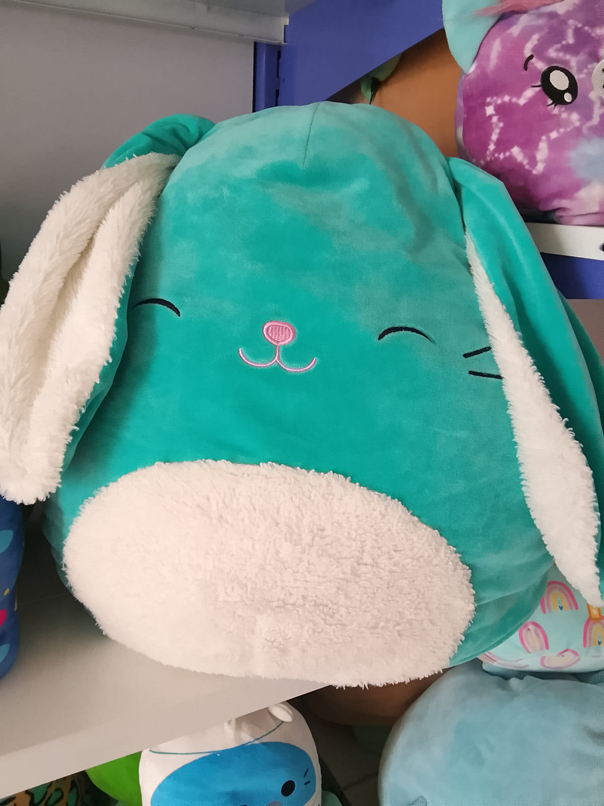 Squishmallows Official Regan the Teal Bunny plush toy.