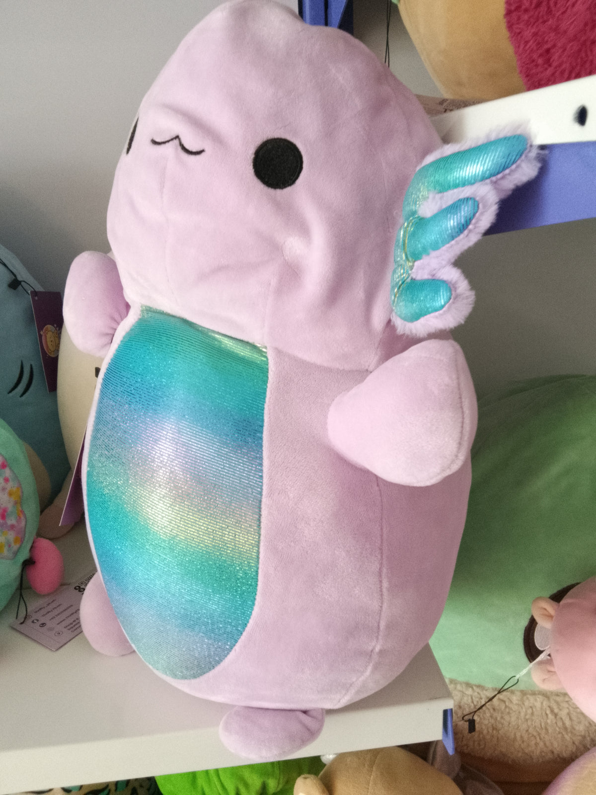 Monica the Axolotl, a light purple character from the Squishmallows Hug Mees line by Kellytoy.