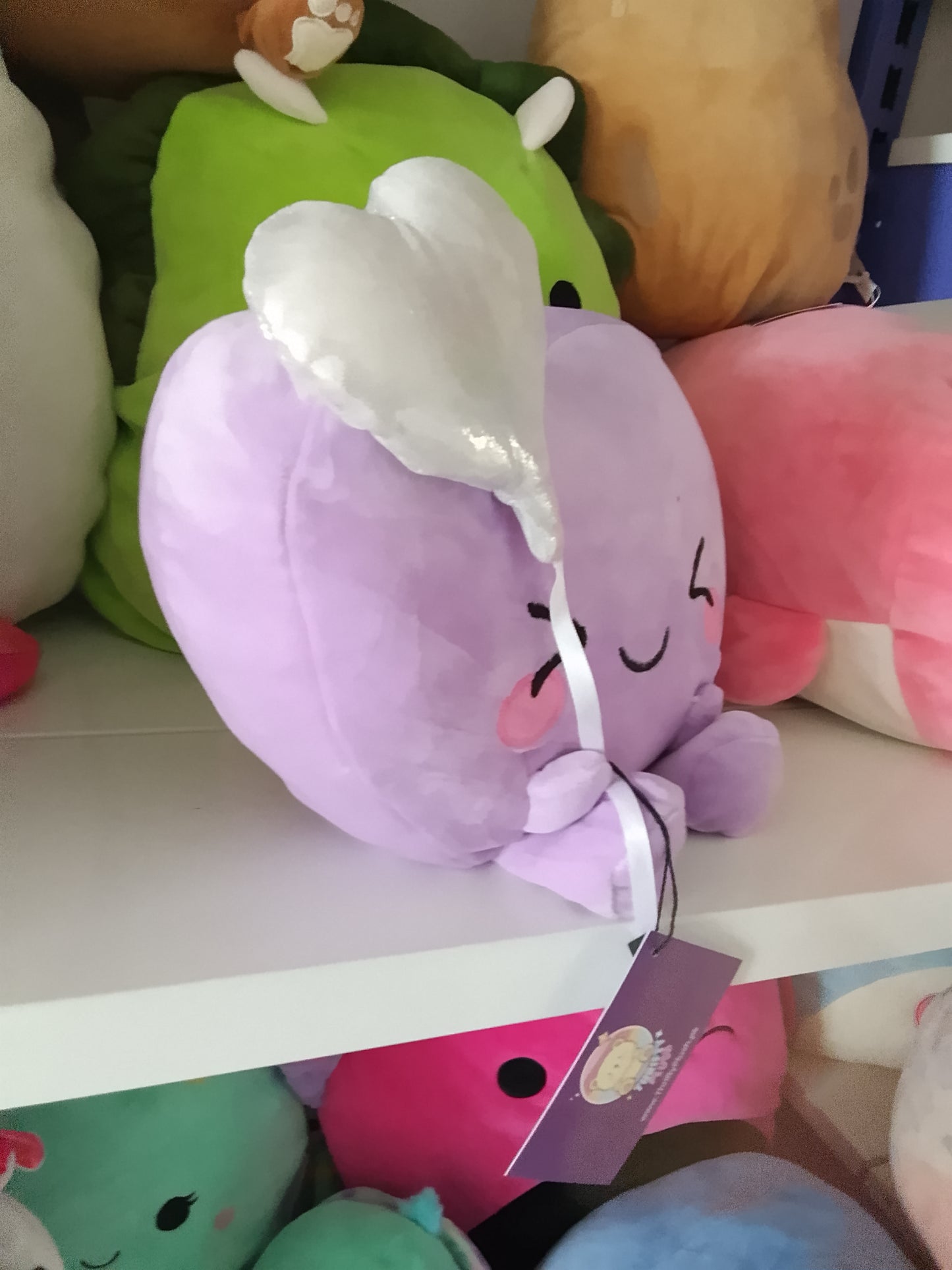 Purple heart holding a white balloon plush toy.