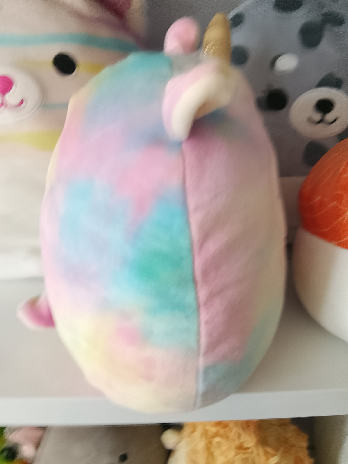Squishmallows Lucinda the Llamacorn plush toy, featuring a rainbow tie-dye design.