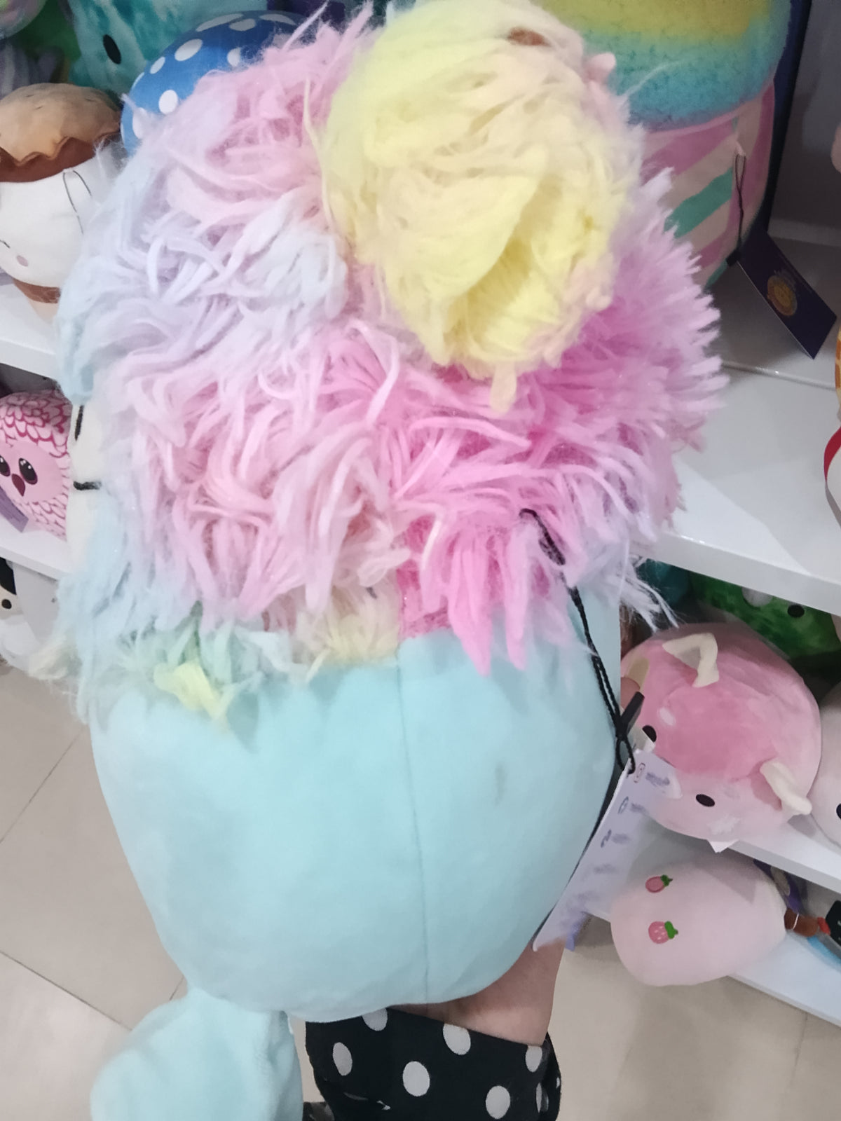 Squishmallows Zozo the Bigfoot plush toy in blue with rainbow hair.