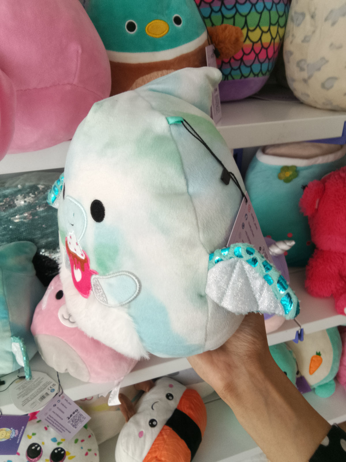 Squishmallows Shantira the Pterodactyl plush toy blue and white tie-dye design and holding a hot chocolate cup.