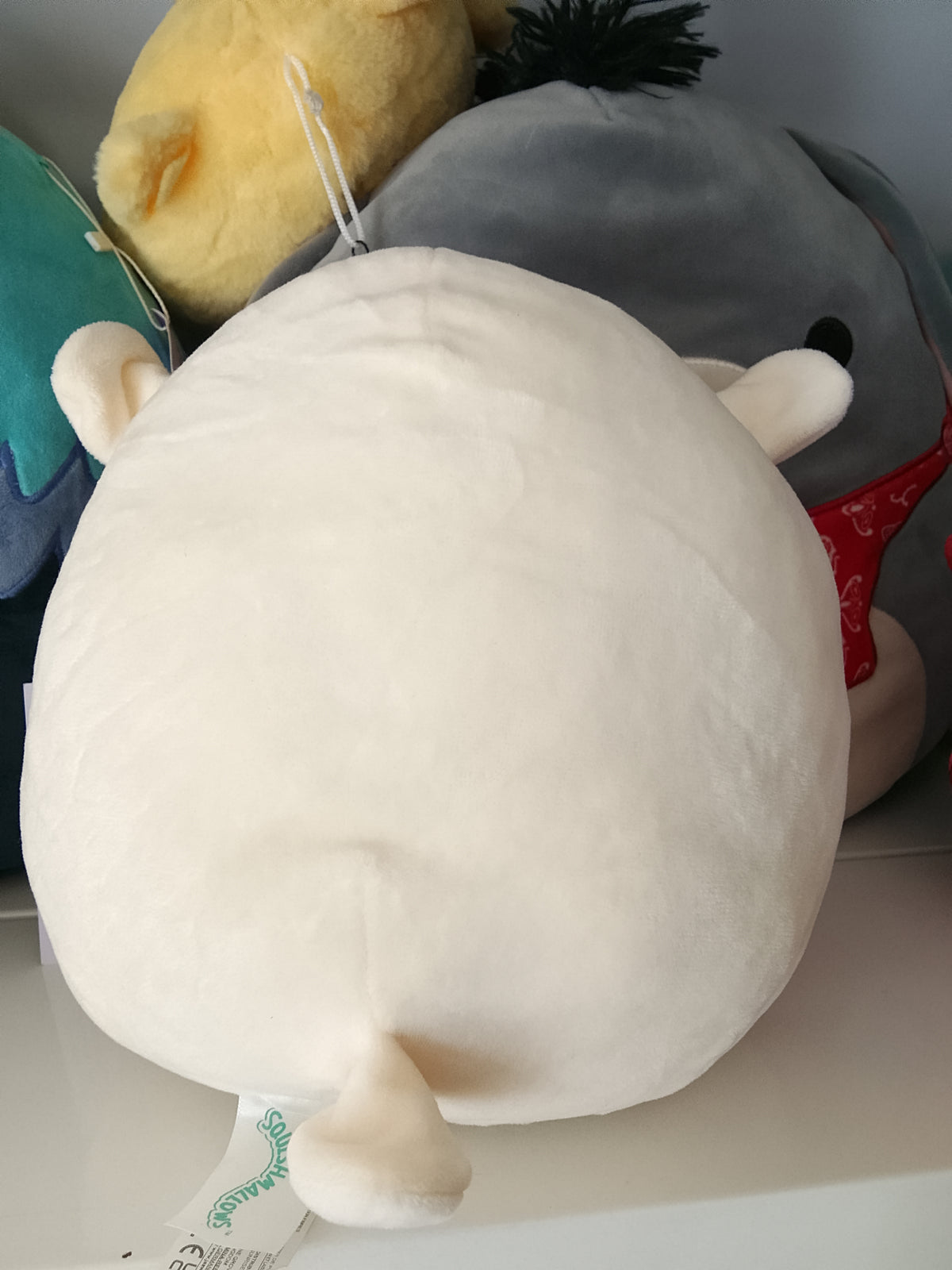 Squishmallows character Sophie the Lamb, rainbow-colored belly plush toy.