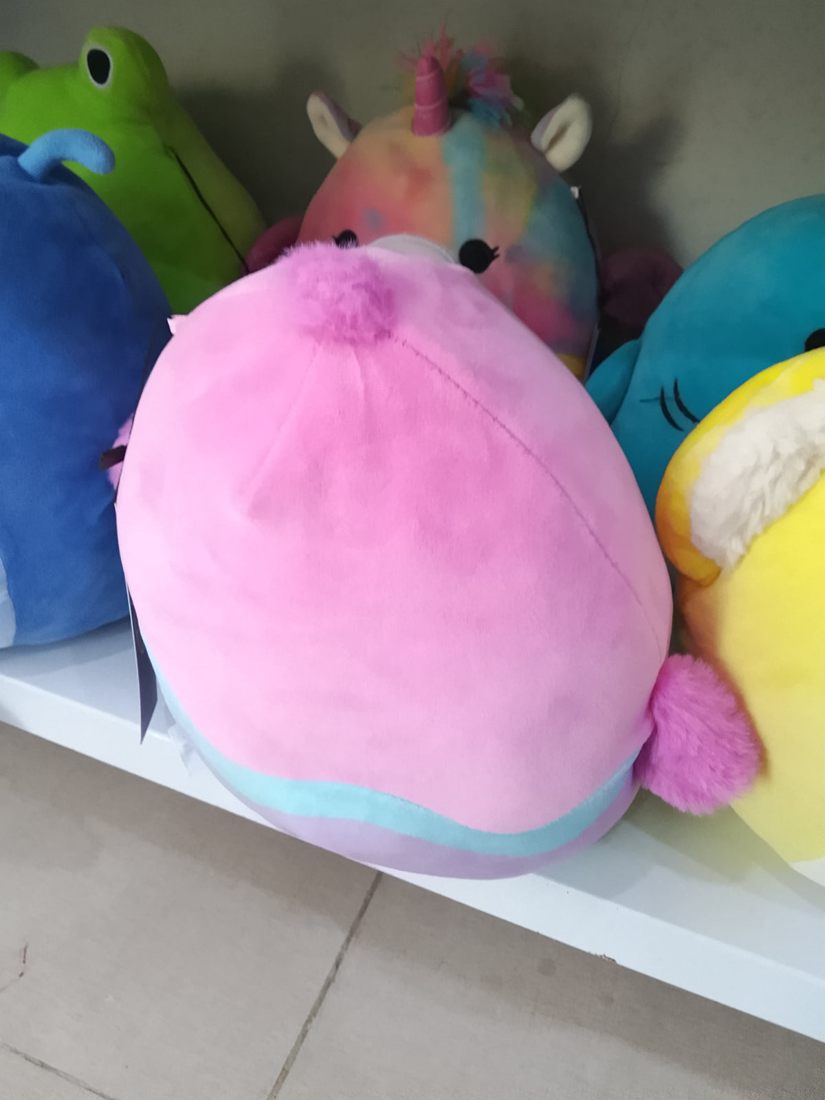 Squishmallows Empressa the Chick plush toy with a pink, blue, and yellow easter egg design.