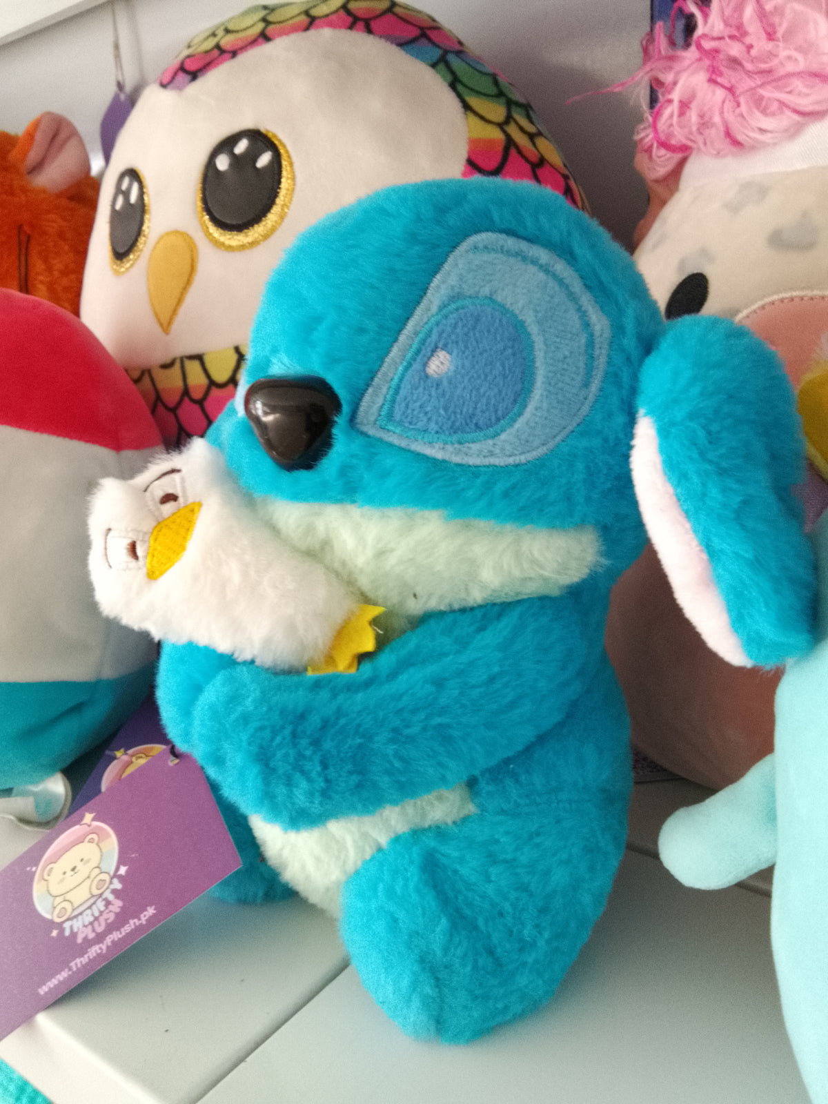 Stitch holding a smaller white duck Plush toy.