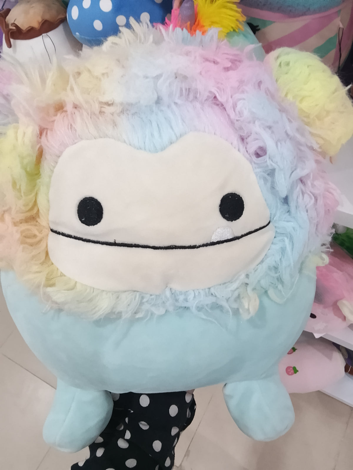 Squishmallows Zozo the Bigfoot plush toy in blue with rainbow hair.