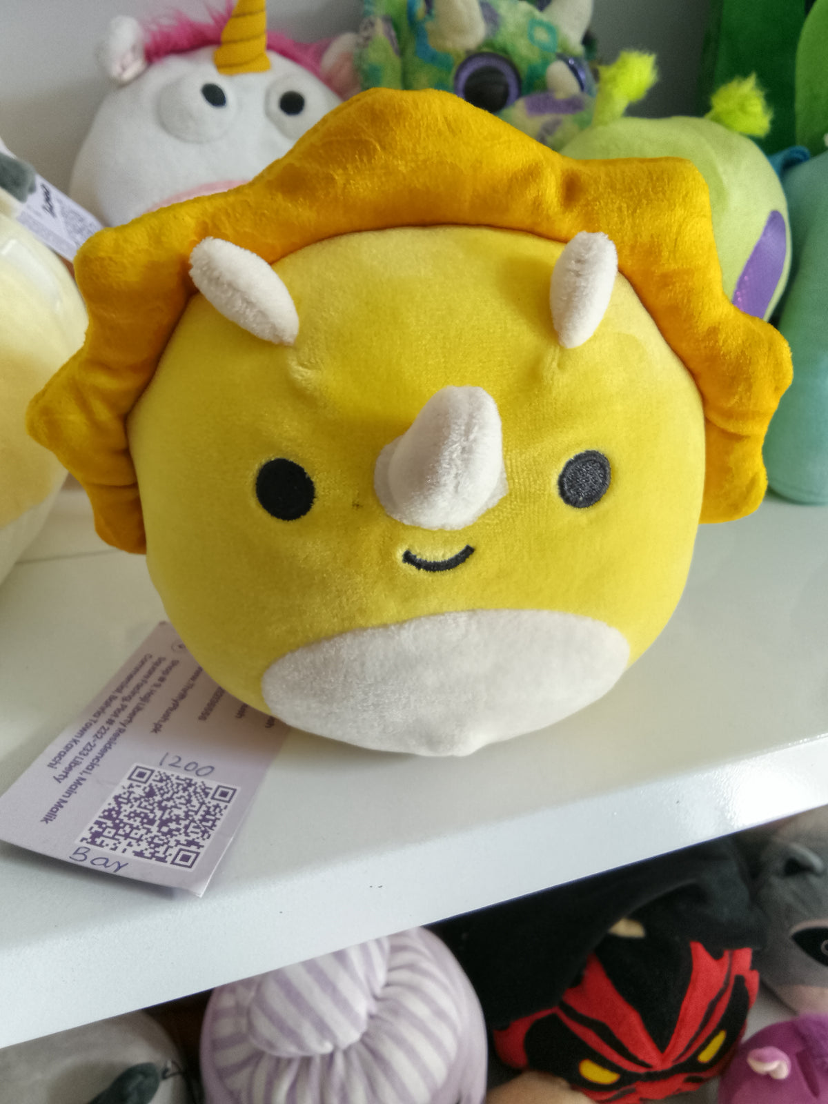 Squishmallows Lancaster the Triceratops, yellow color, soft texture, and dinosaur design plush toy.