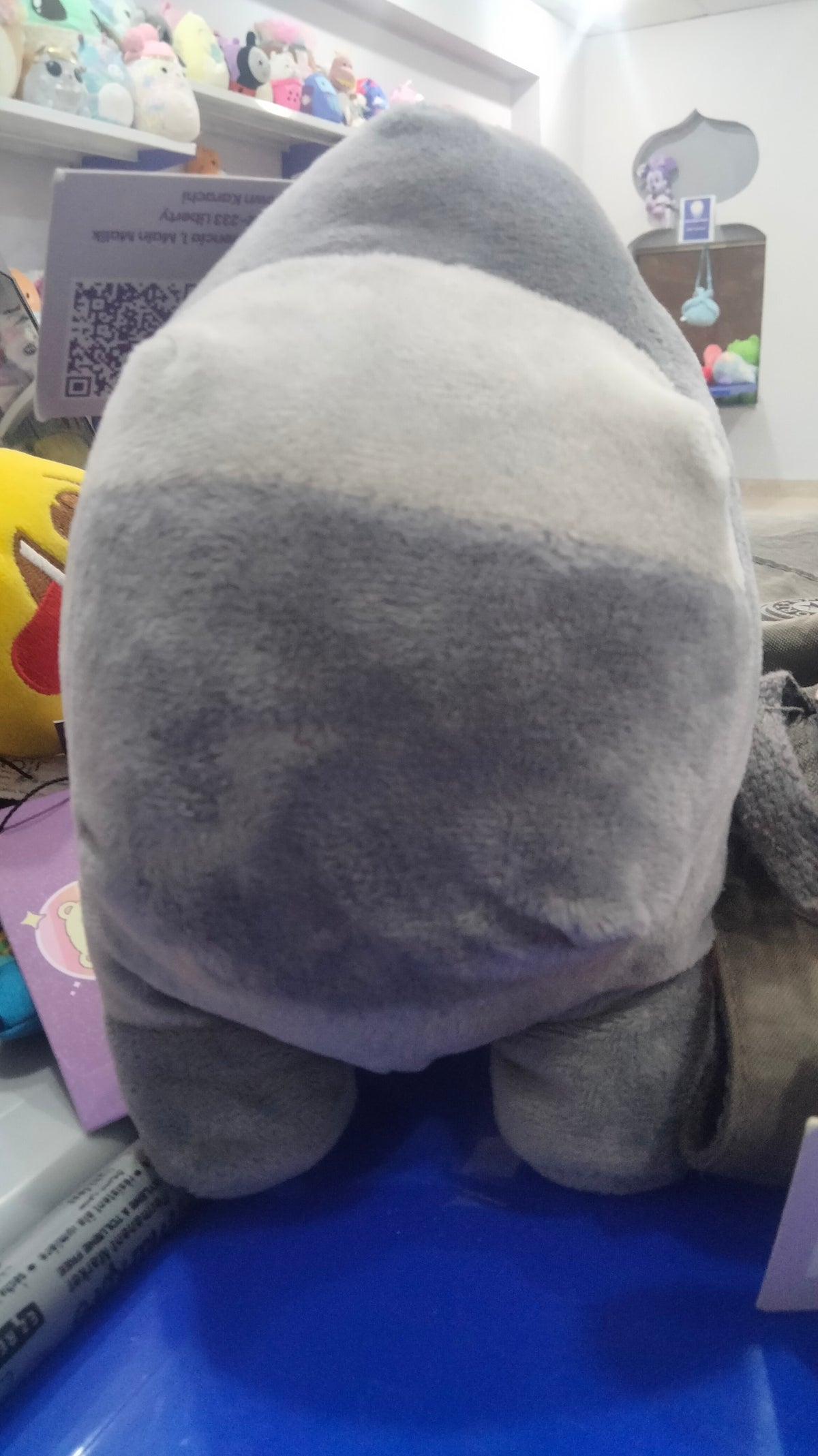 grey Among Us plush toy featuring a light blue visor.