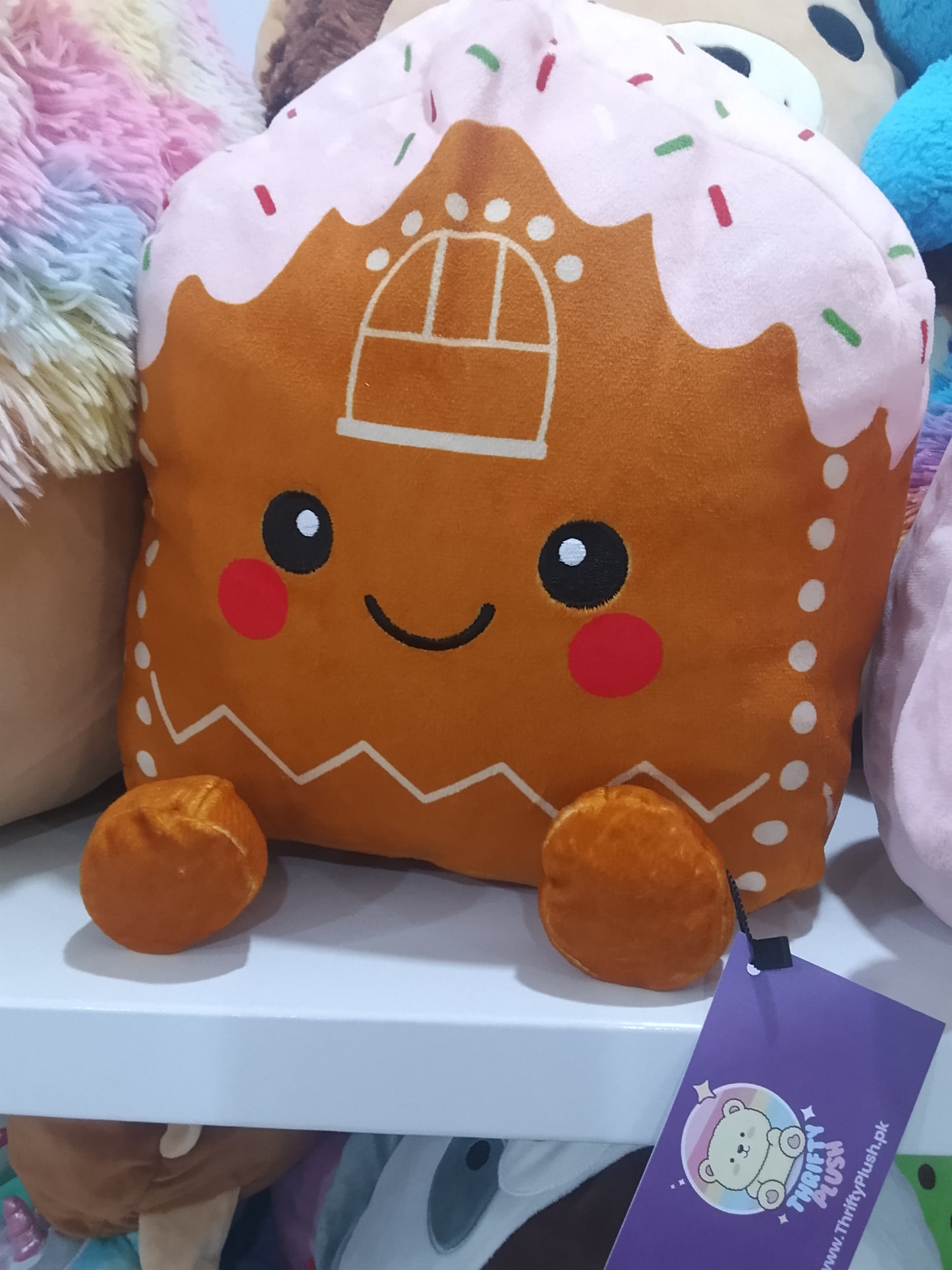 Gingerbread House soft toy with a pink icing top and cute dangling legs.
