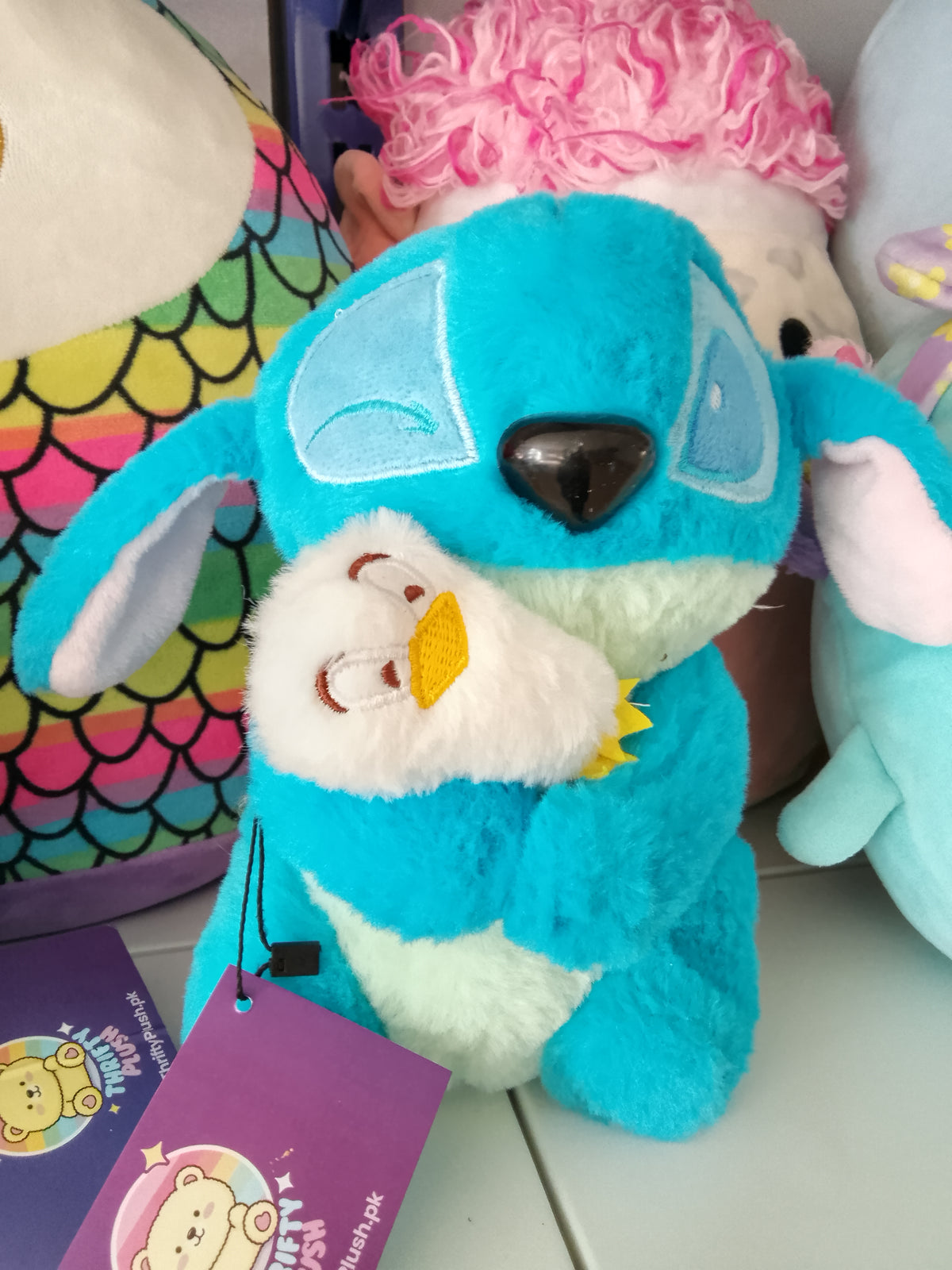 Stitch holding a smaller white duck Plush toy.