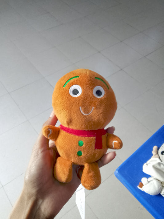 plush gingerbread man toy featuring a red scarf and green buttons.