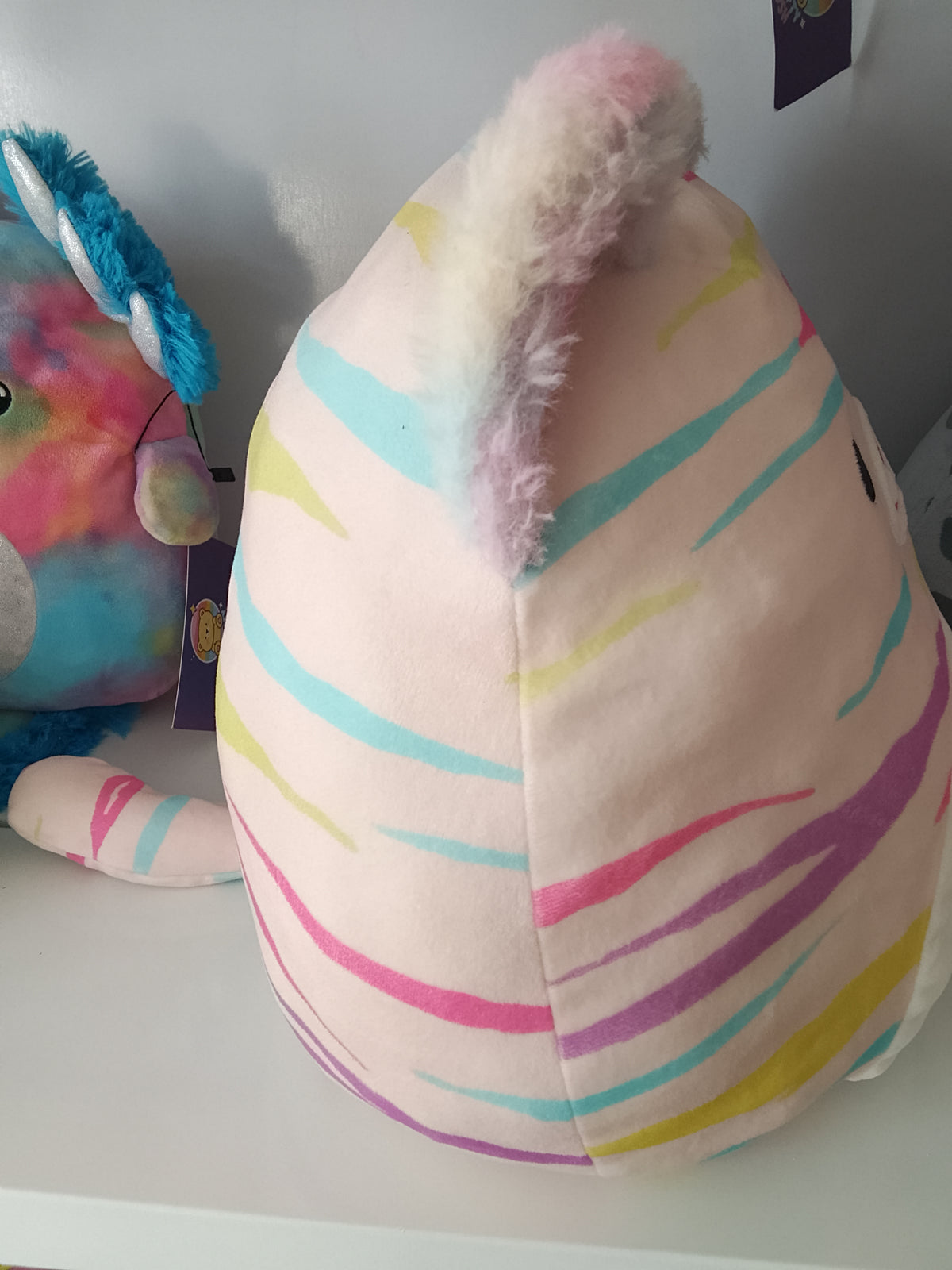 Squishmallows Atoosa the Cat, pastel rainbow stripes and shimmering pink ears plush toy.